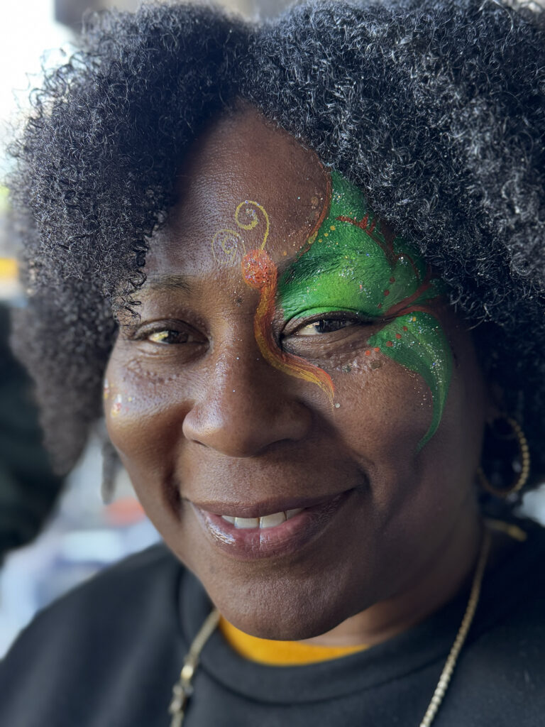 An adult woman posing for a photo with a design by Face Painters NH