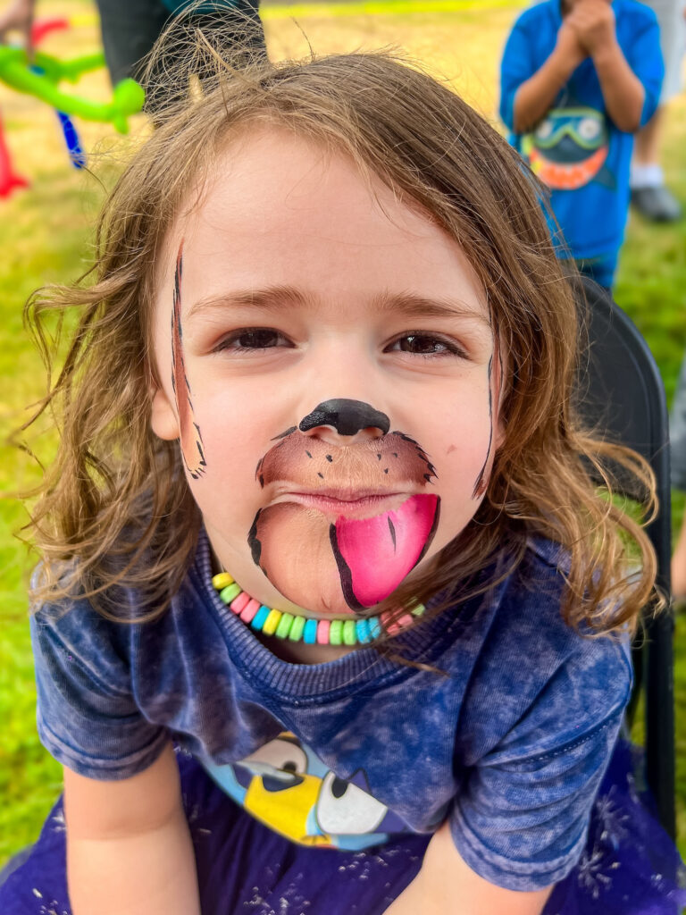 A small child with a dog face painting