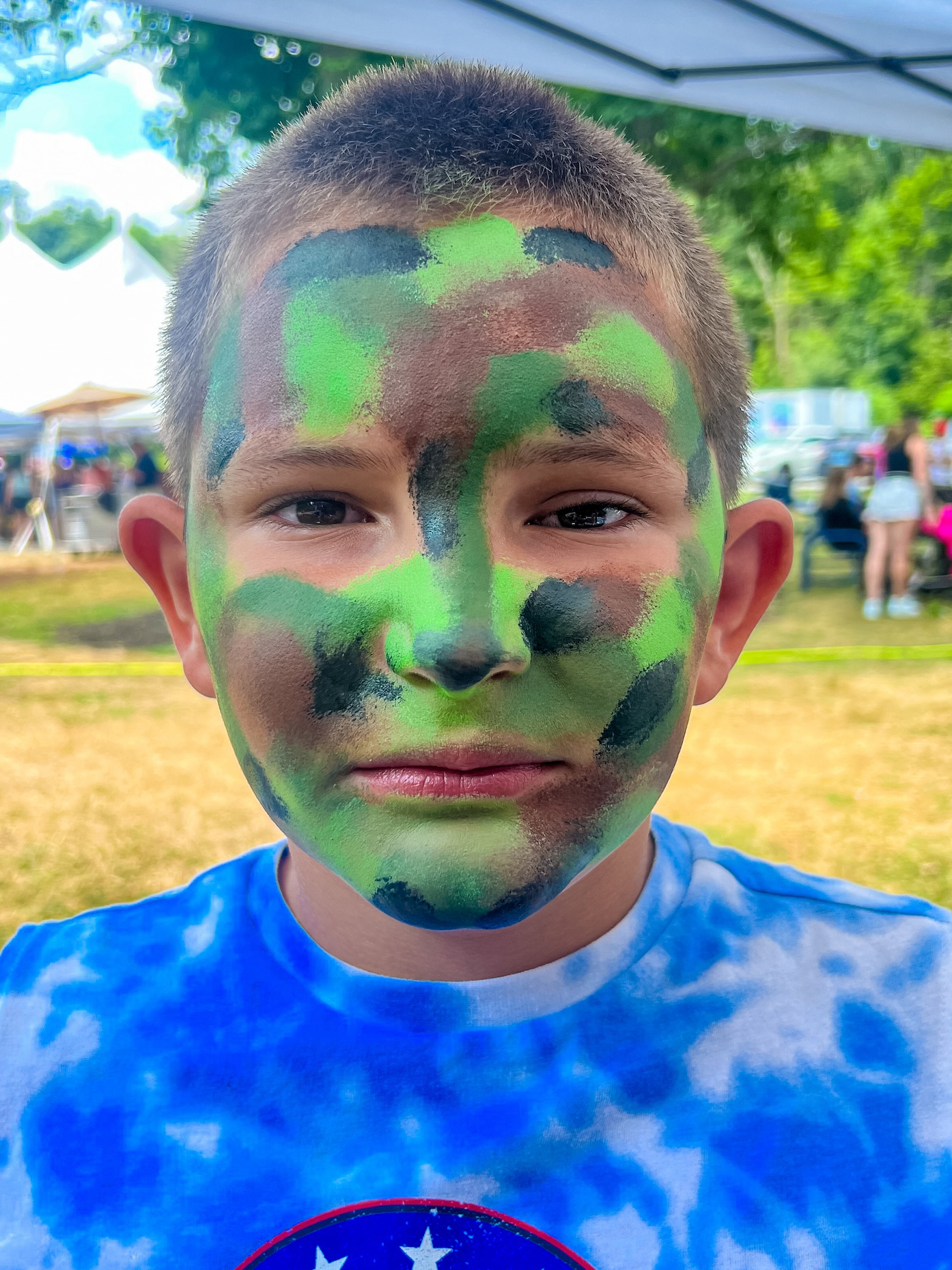 A boy with a camo face painting