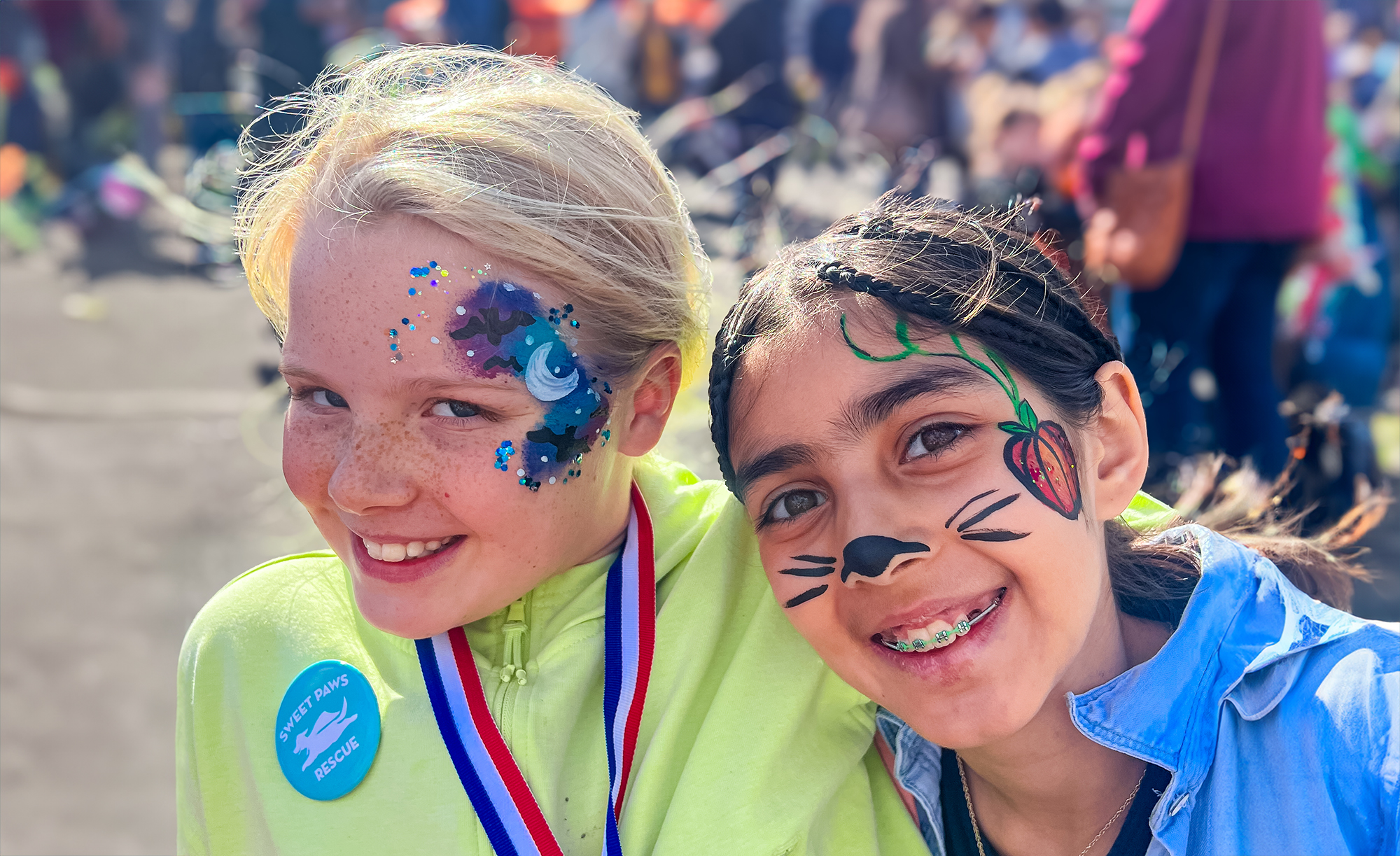 Two girls laughing outdoors with face paint done by Face Painters NH