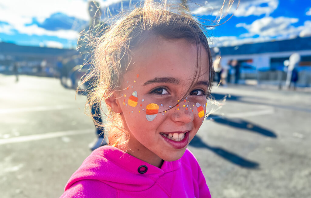 A girl smiling with candy corn face paint